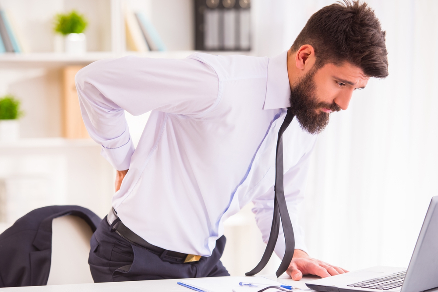 businessman with a beard while working in his office, holding behind his back