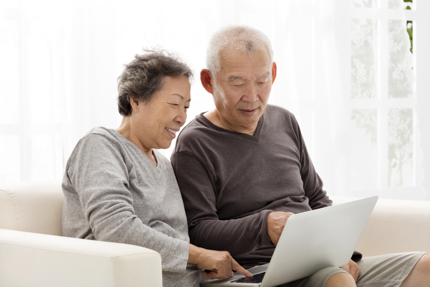 happy Senior Couple Using Laptop on sofa