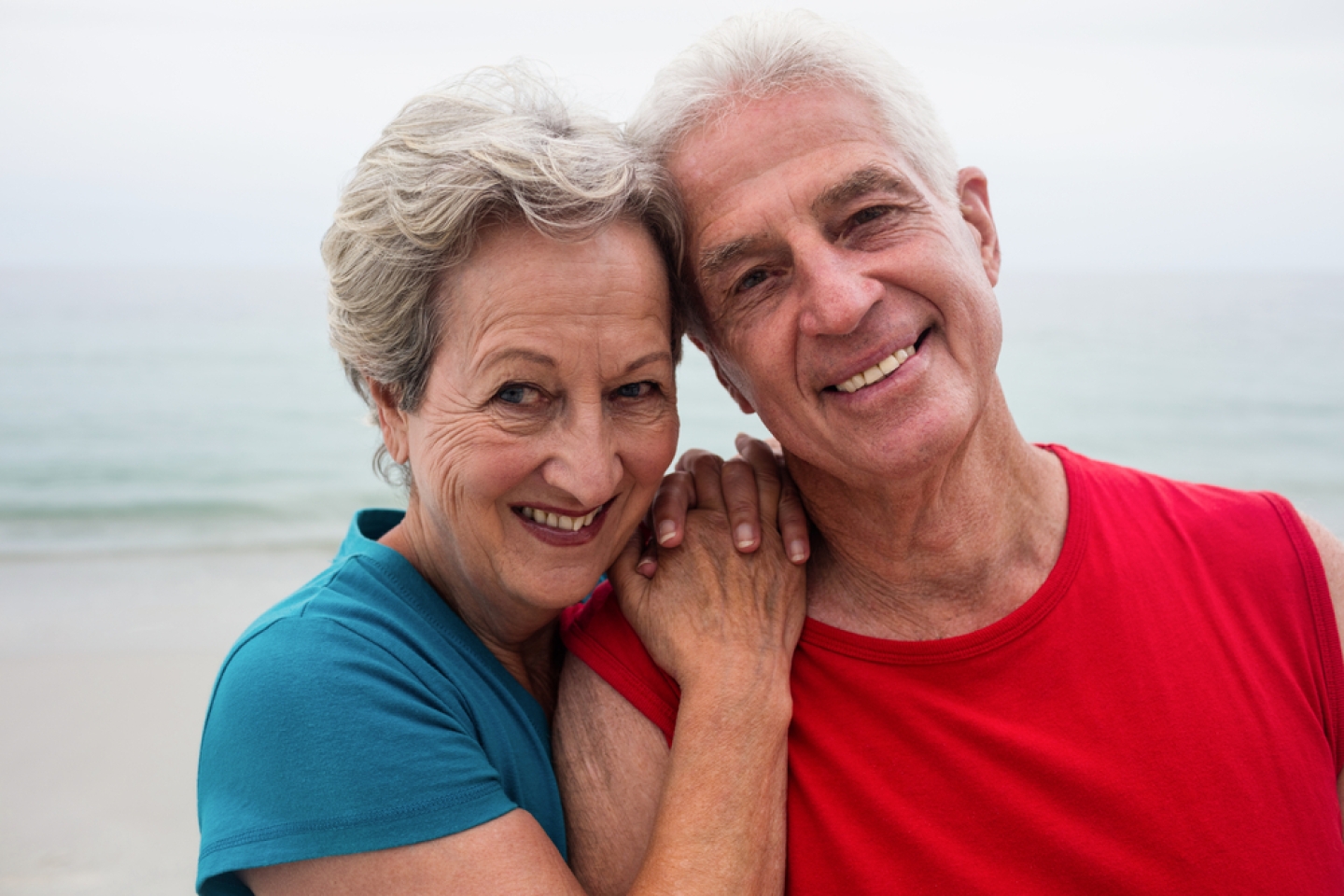 Happy senior couple embracing each other on the beach on a sunny day