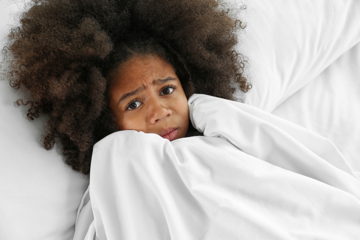 young black child scared in bed