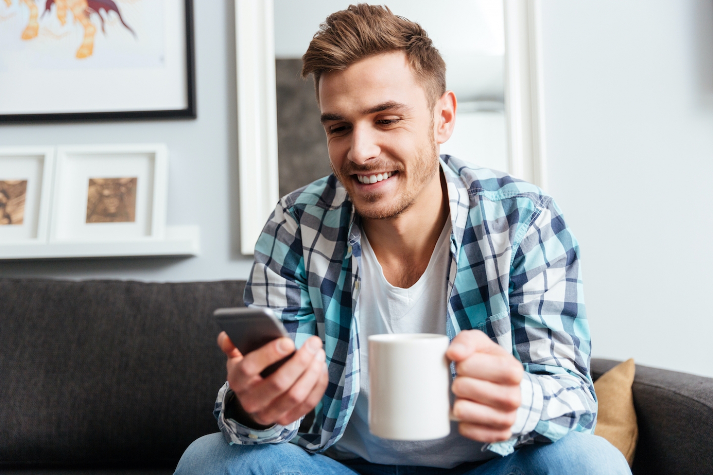 man with phone and cup in hand