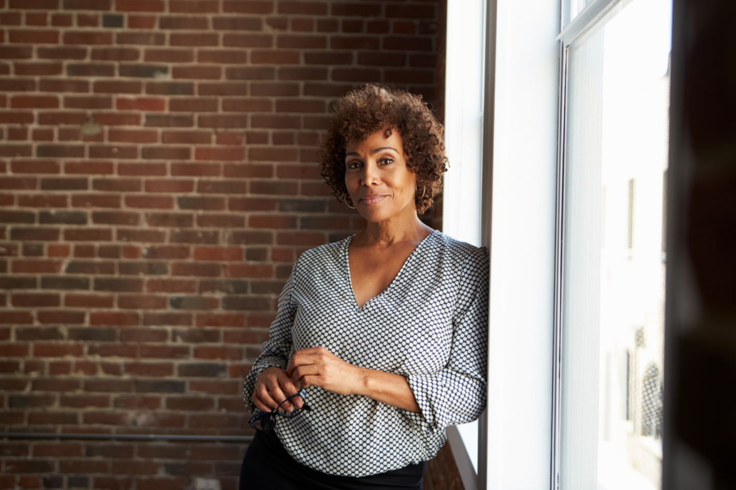 Mature Businesswoman Standing By Office Window