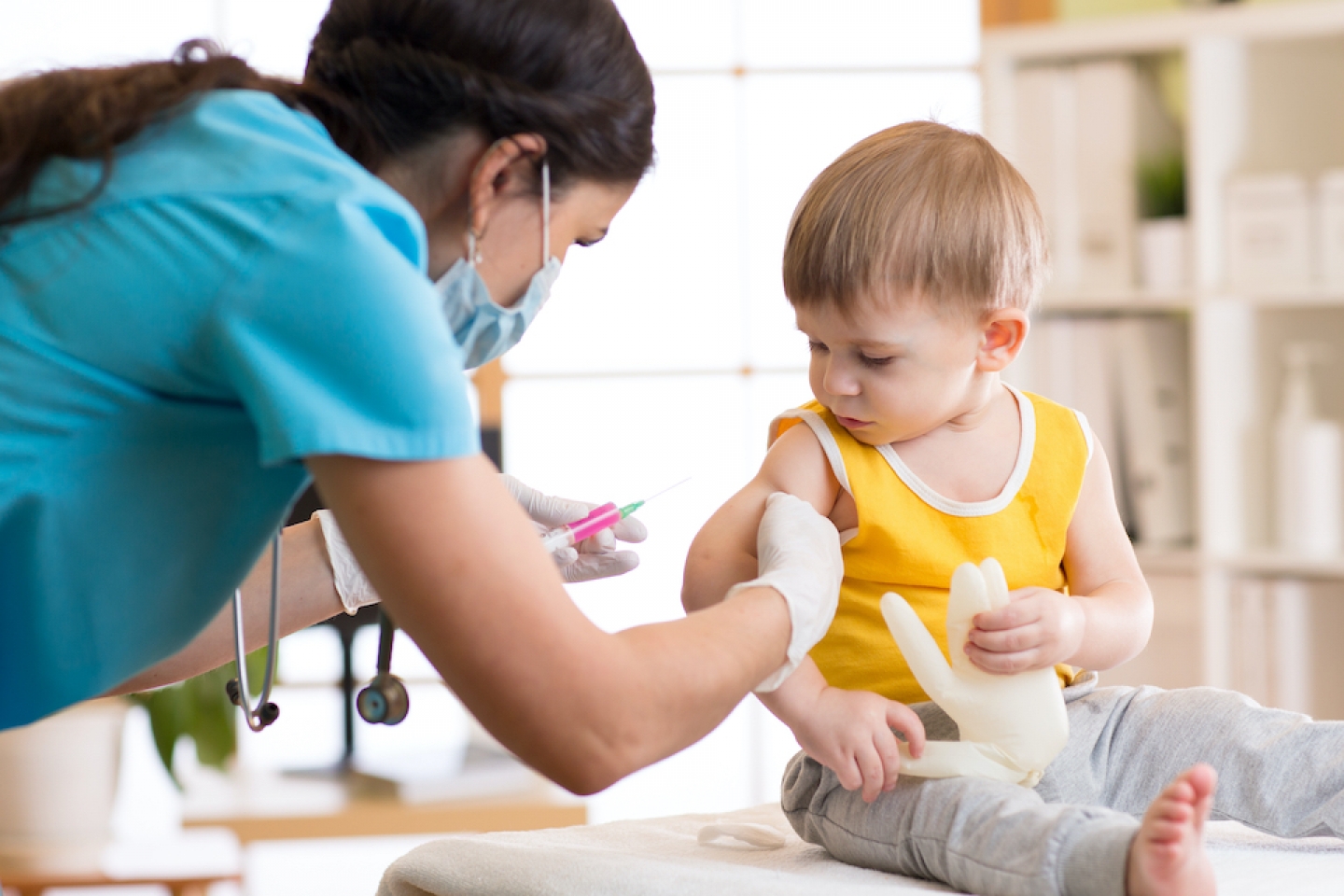 child receiving a vaccine from doctor