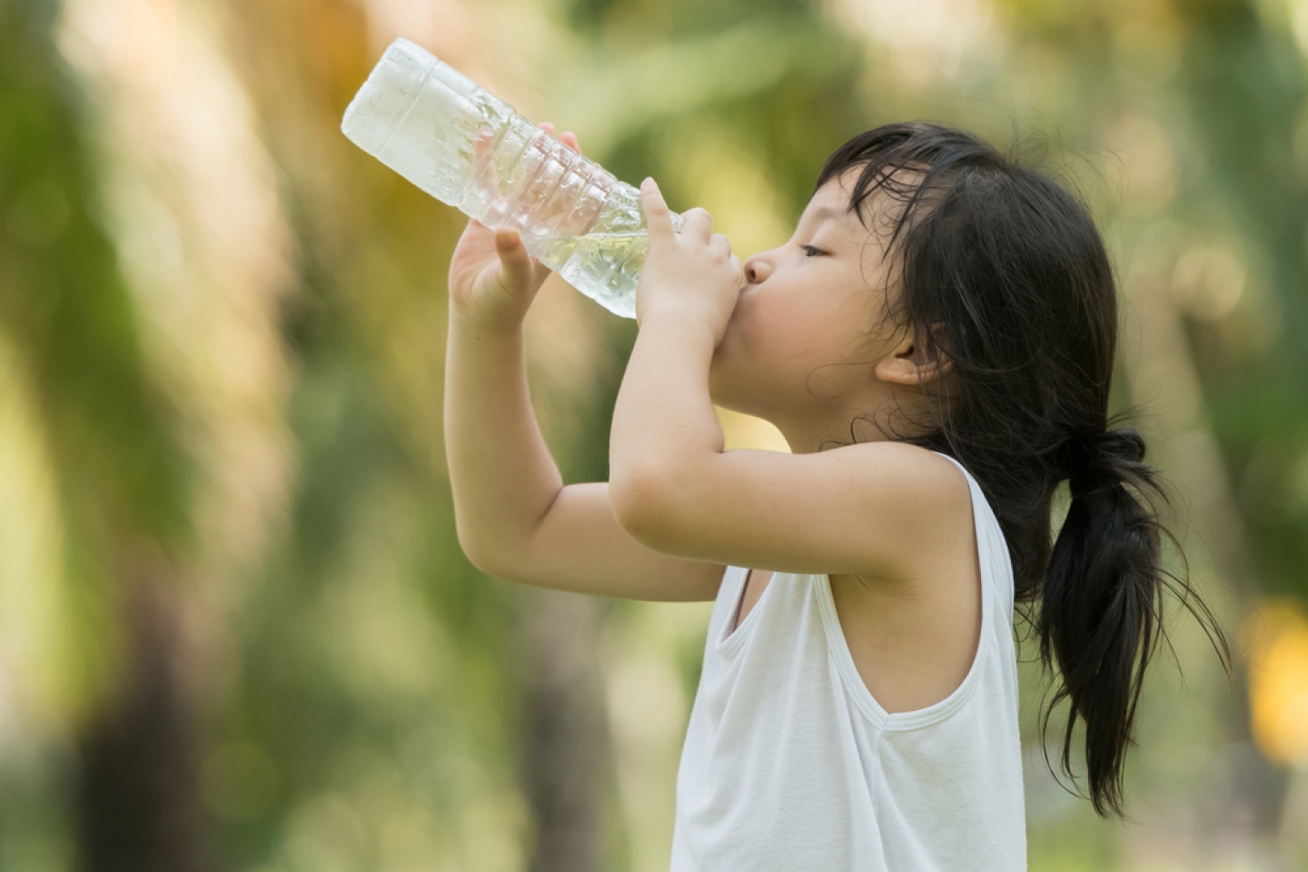 Child drinking pure water in nature