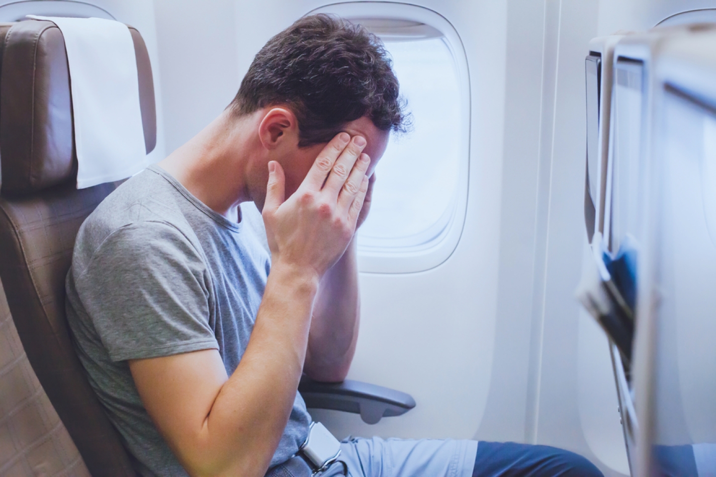 headache in the airplane, man passenger afraid and feeling bad during the flight in plane