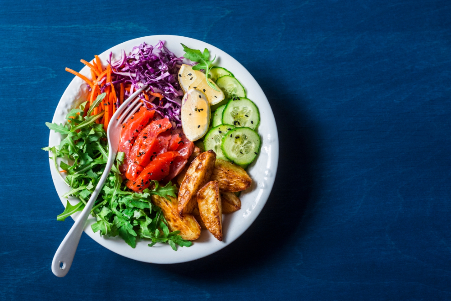 Red cabbage, carrots, arugula, potatoes, smoked salmon fish bowl.