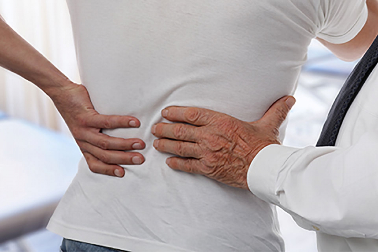 Physician examines patient with back pain.