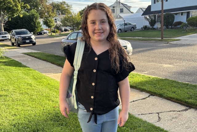 Emma standing with backpack