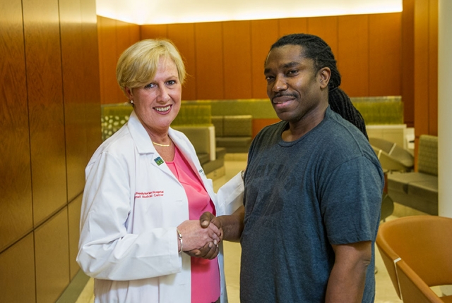 Patient and doctor pose for a photo