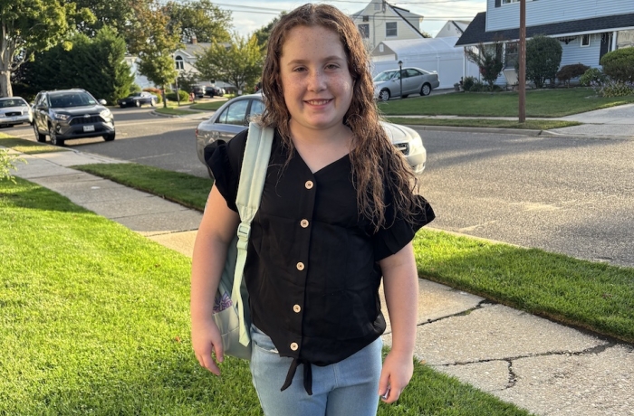 Emma standing with backpack