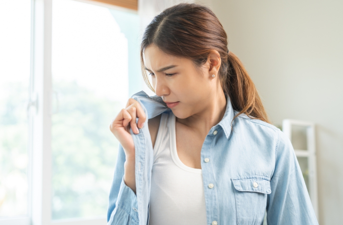 women smelling her shirt