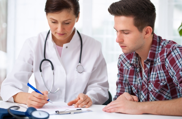 doctor talking to her male patient at office