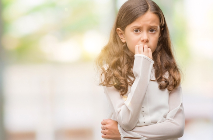 Brunette hispanic girl looking stressed and nervous with hands on mouth biting nails. Anxiety problem.