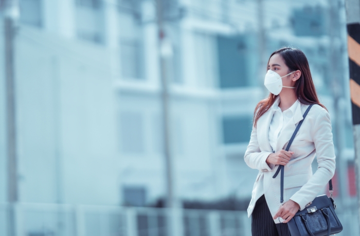 Asian woman are going to work.she wears N95 mask.prevent PM2.5 dust and smog
