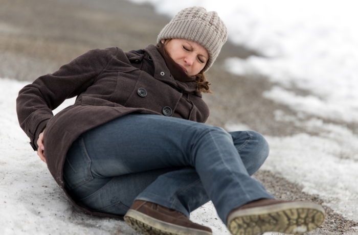 young woman has an accident on a icy way with black ice