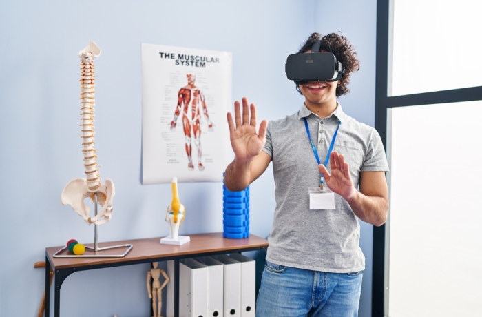 Young hispanic man physiotherapist using virtual reality glasses at rehab clinic