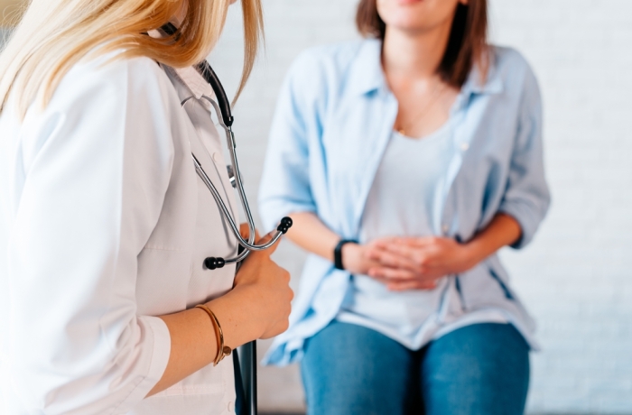 a woman in consultation with a doctor with abdominal pain