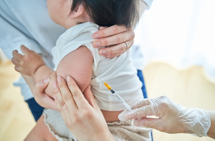 Infants being held by their mothers and receiving vaccinations