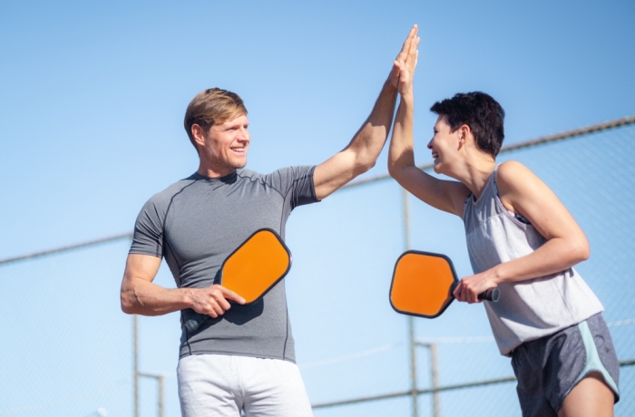  Laughing couple playing pickleball game