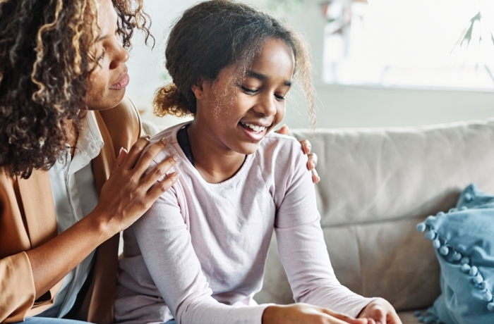 Mother with her teenage daughter at meeting with social worker, psychologist discussing mental health family sitting on sofa in psychotherapist office