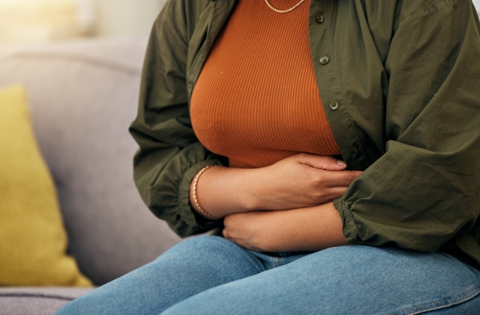 Sick woman, stomach pain and hands on abdomen for ibs, digestion and nausea of pms, virus or anxiety. Closeup female person, menstruation or belly problem of constipation, gut health or endometriosis