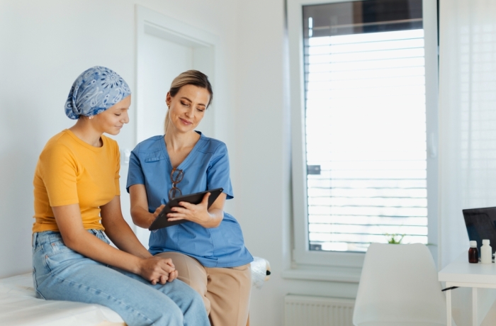 Teenage oncology patient talking with doctor. Oncologist treating teen girl with cancer and provide emotional support, helping her with anxiety and depression.