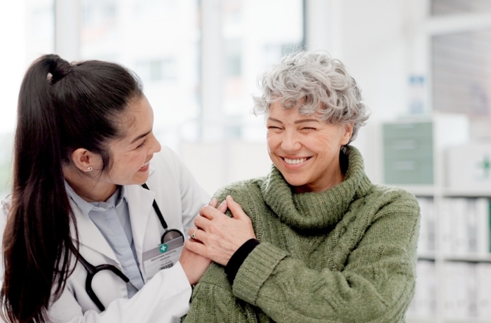 Happy, care and face of a doctor with a woman for medical trust, healthcare and help.