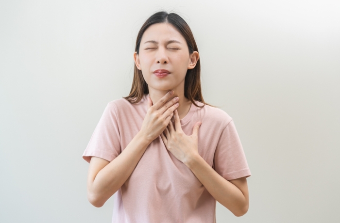 Acid reflux disease, suffer asian young woman have symptom gastroesophageal, esophageal, stomach ache and heartburn pain hand on chest from digestion problem after eat food, Healthcare medical concept
