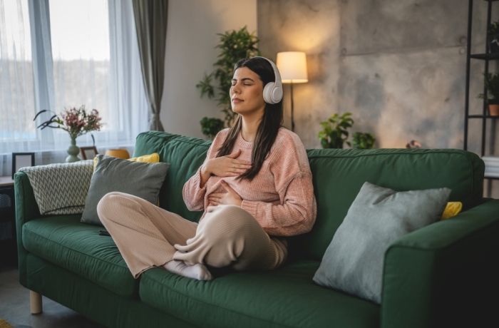 one woman adult caucasian female millennial using headphones for online guided meditation practicing mindfulness yoga with eyes closed at home real people self care concept copy space