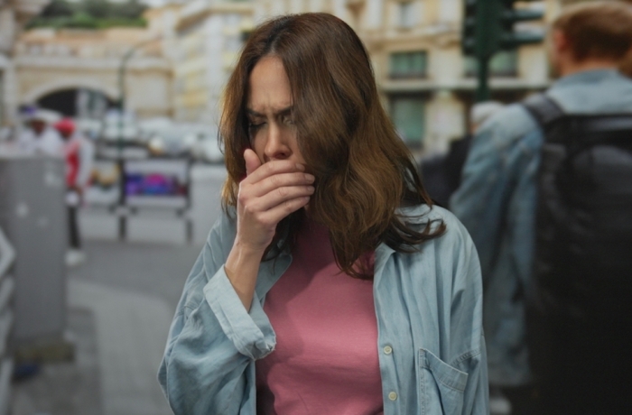 woman coughing outside