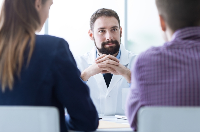 Young couple at the doctor's office during a visit, medical advice and consultation concept