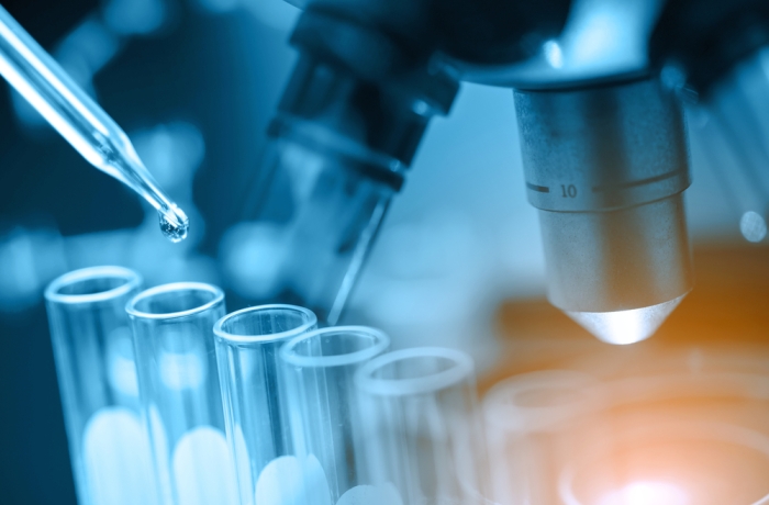 microscope with lab glassware, science laboratory research and development concept