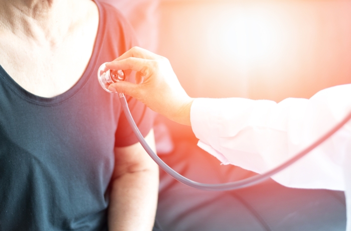 Cardiovascular disease in the elderly concept. Professional doctor using stethoscope with female elderly patient to listen heart and lung to cure chronic disease.