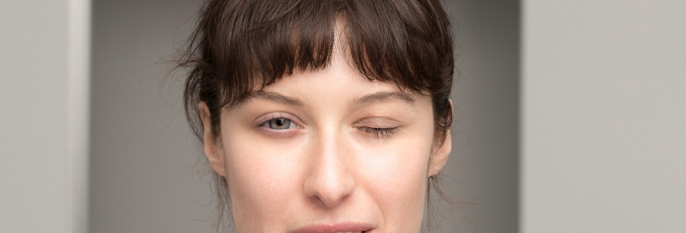 woman with a half-closed eye affected by myasthenia