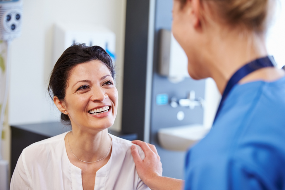 Patiente souriant au fournisseur féminin.