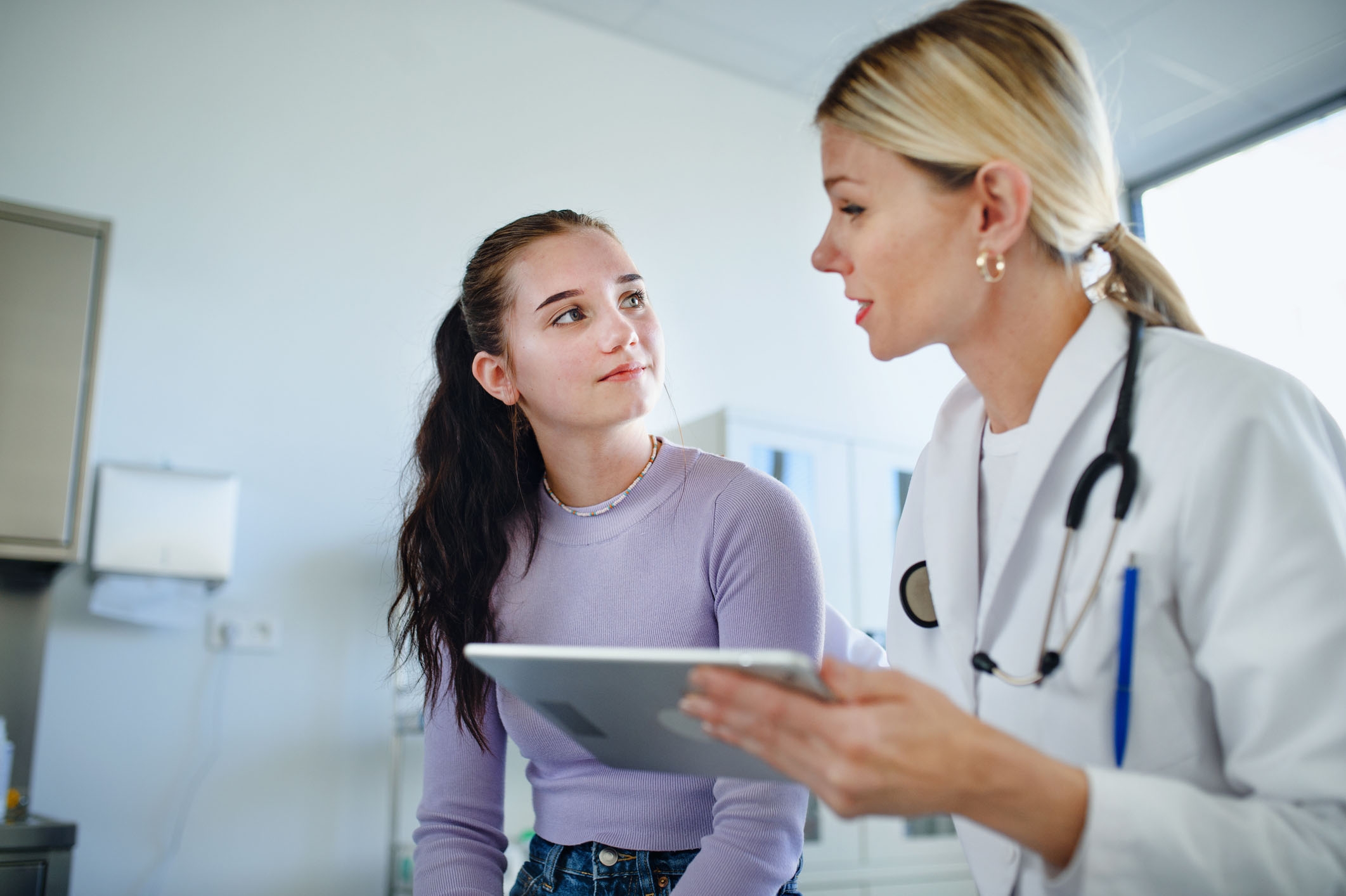 Female teen patient looks at her doctor during an appointment