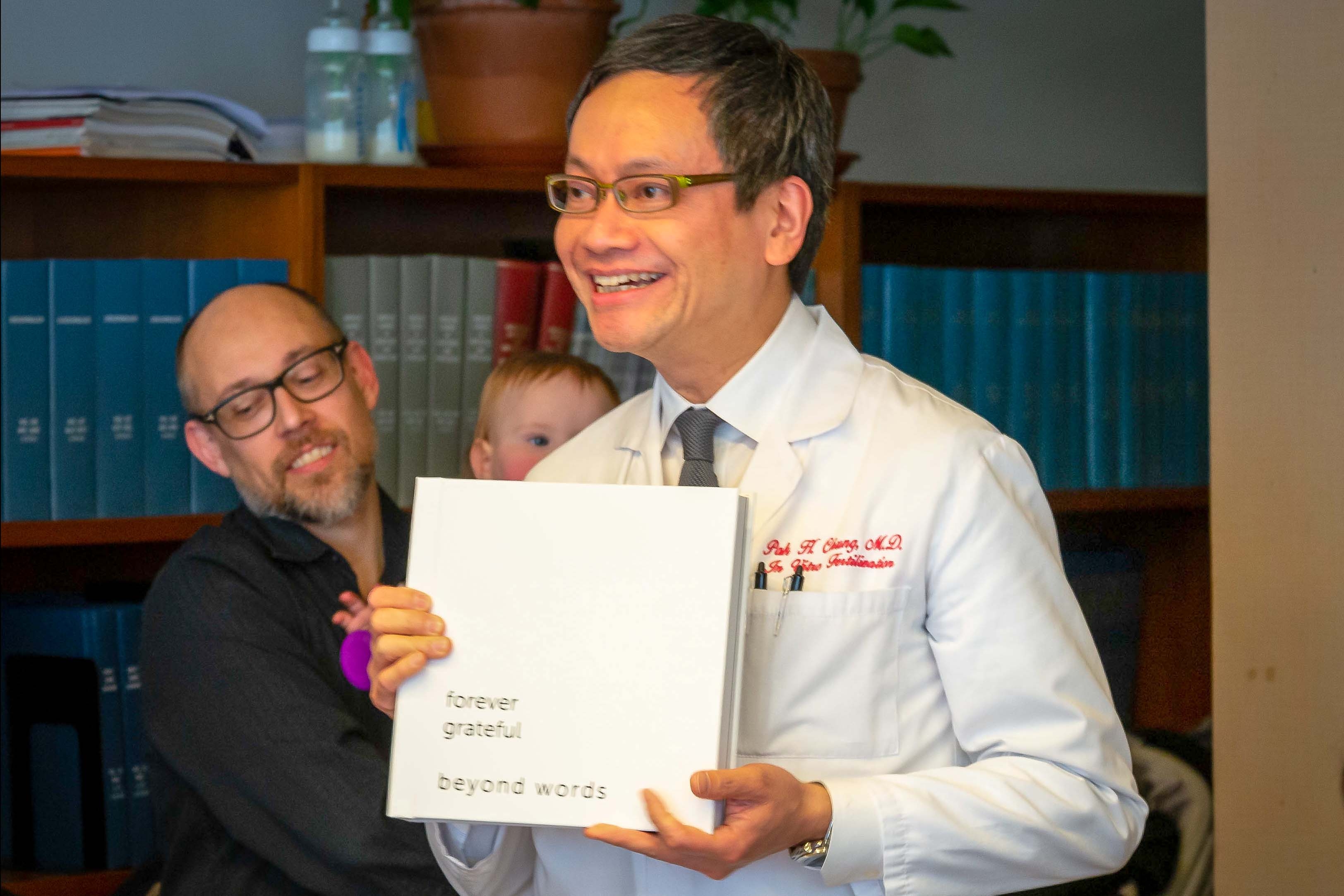 Dr. Pak H. Chung poses with an album gifted by patients.