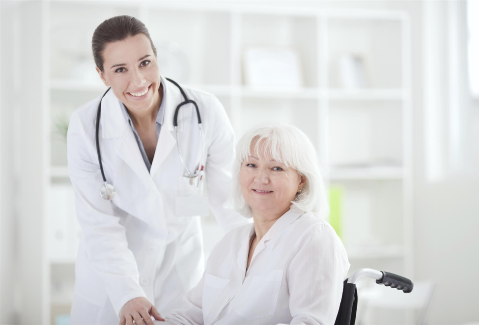 Female doctor stands with elderly female patient