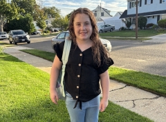 Emma standing with backpack