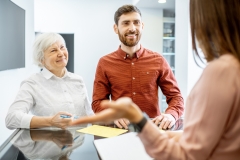 Older woman with adult son talking to doctor