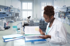 Female researcher reviewing notes in a lab