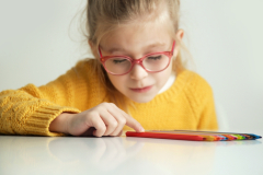 A little girl counting color pencils