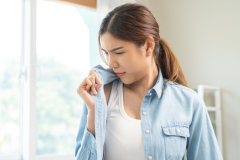 women smelling her shirt