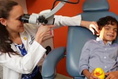 dr maresh conducts ear exam on child patient