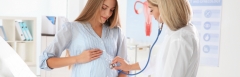 A doctor performs a medical checkup on a pregnant woman.