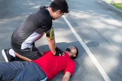 Men are doing first aid by Cardiopulmonary Resuscitation or CPR to friends with sudden cardiac arrest. During exercise together Within the park