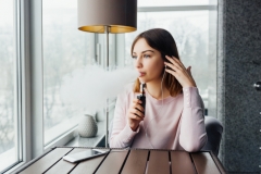 Young women smoking ( vaping ) e-cigarette with smoke