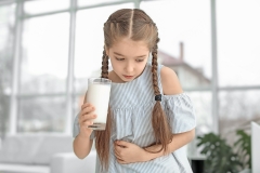 child with milk in her hand