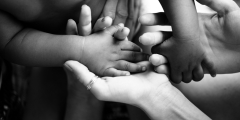 black white photo of family holding baby's hand