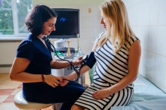 Friendly female doctor measuring pressure of the pregnant woman.
